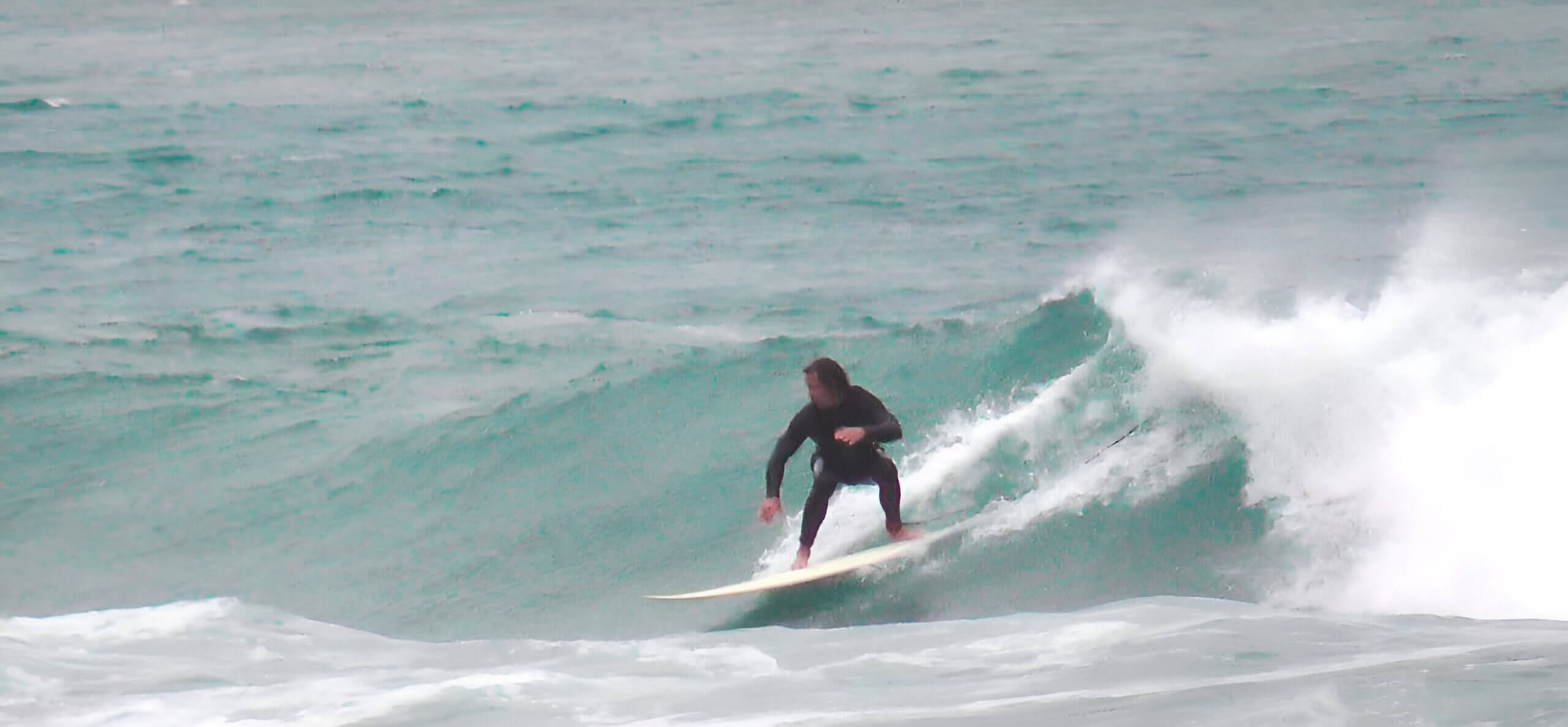 Surfer riding a green wave in Da Nang Vietnam — beginner-friendly surfing conditions