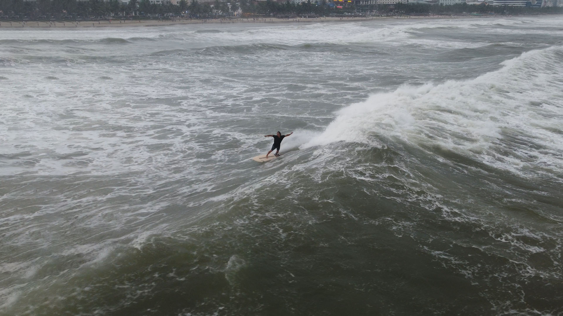 Surfer riding a green wave in Da Nang Vietnam — beginner-friendly surfing conditions