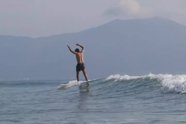 A surfer riding a wave during a private lesson in Da Nang