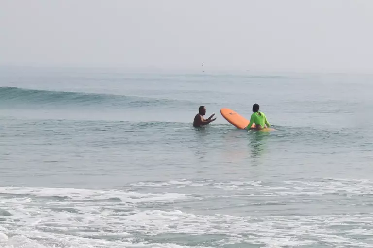 A surf lesson with an instructor in the water in Da Nang