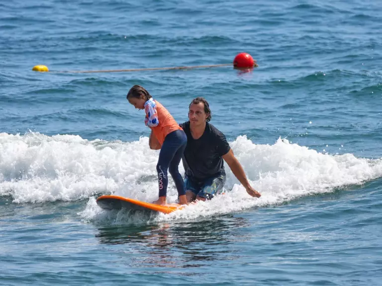 Instructor Anton helping a student on her board during a surf lesson in Da Nang