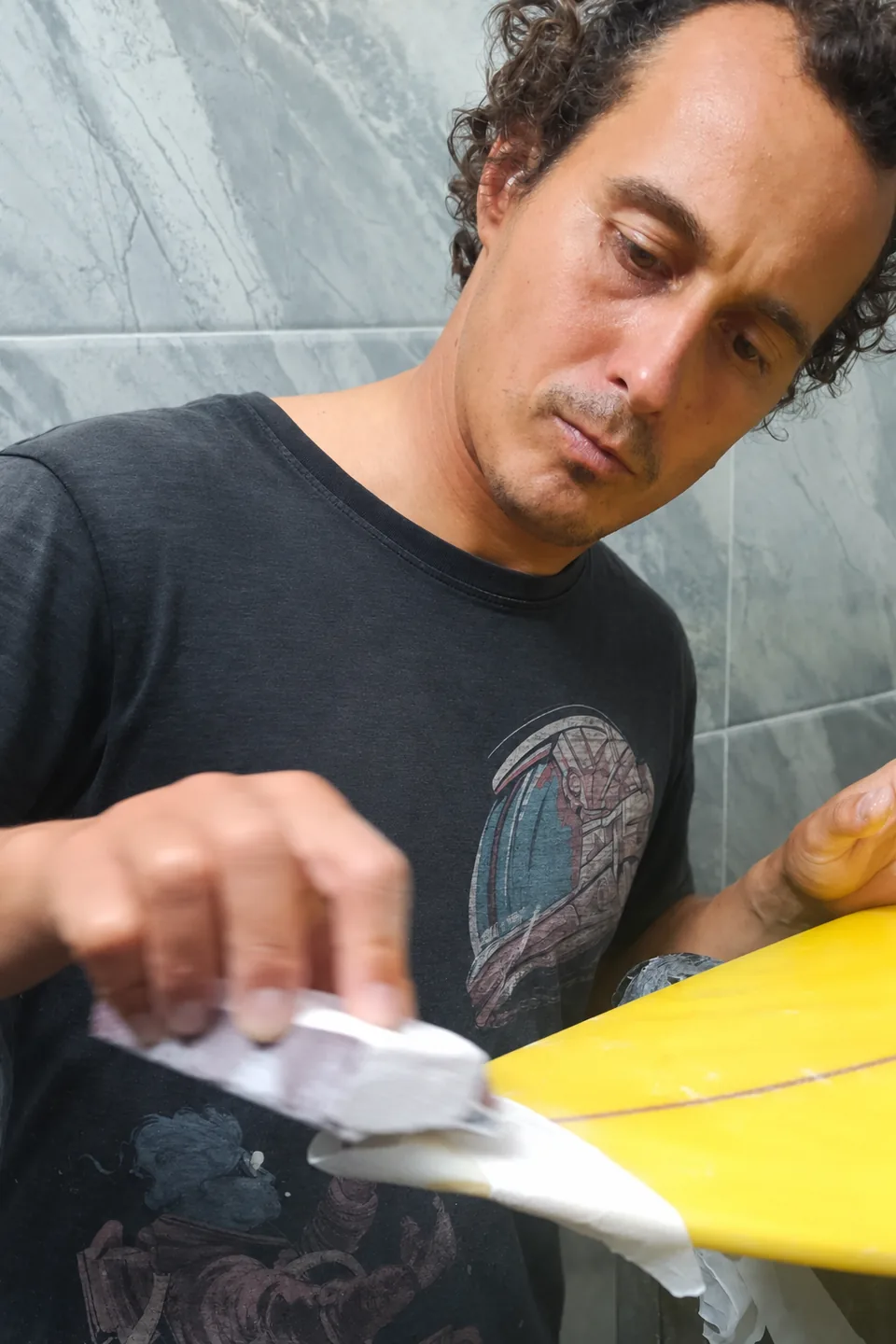 Anton sanding a surfboard during repair at SlicedWaves